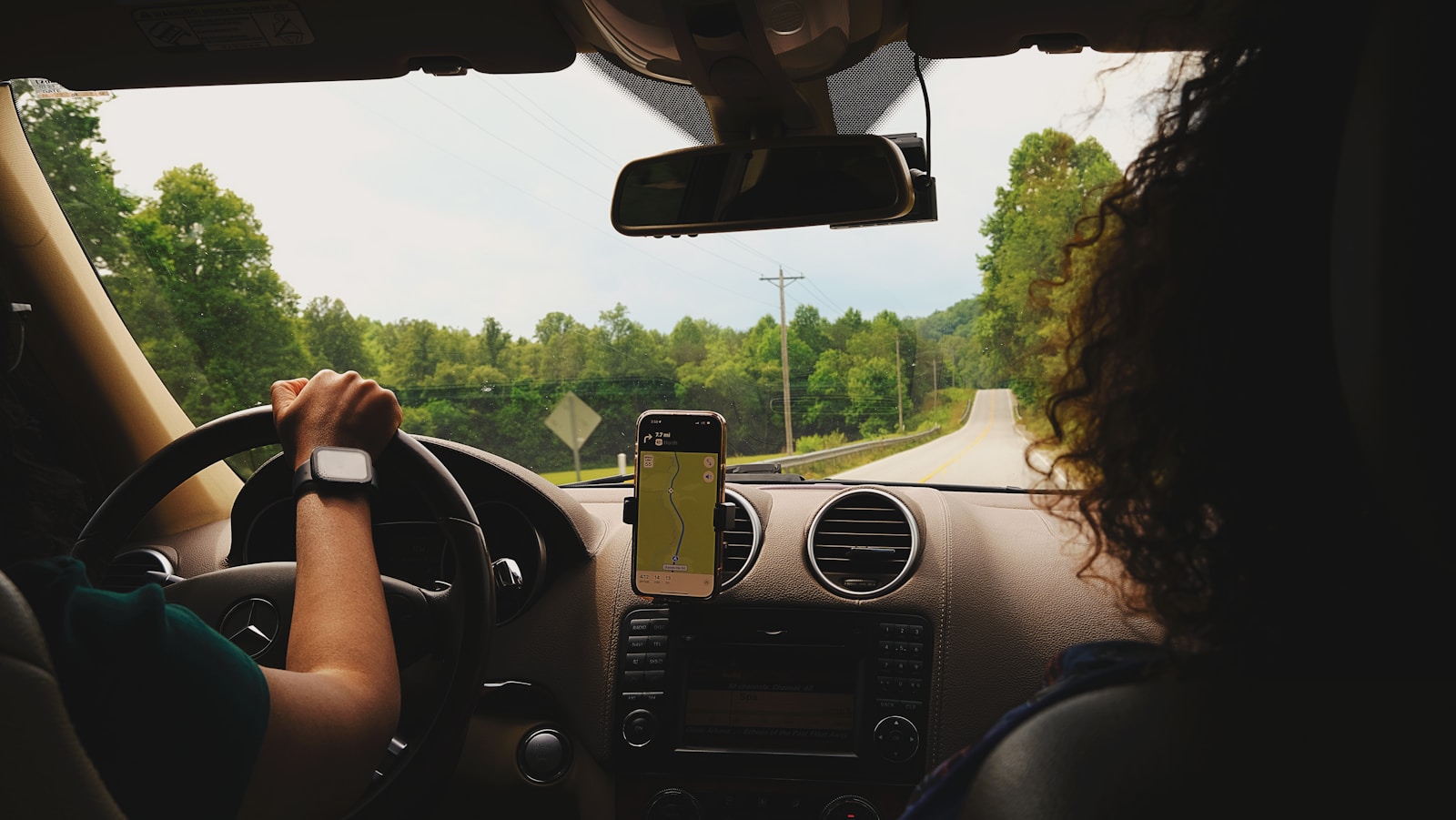 a woman driving a car while holding a cell phone